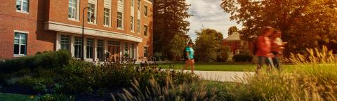 UNH students strolling outside the Peter T. Paul College building