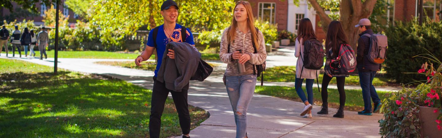 Male and female student walking on campus