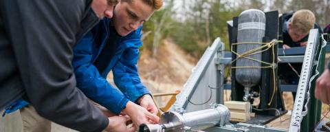 Male students working on engineering project outside