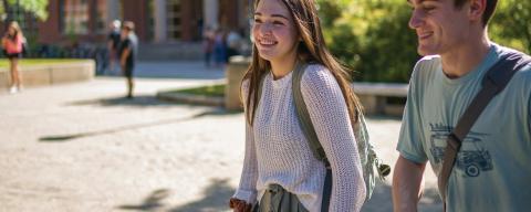 Male and female student walking outside in summer