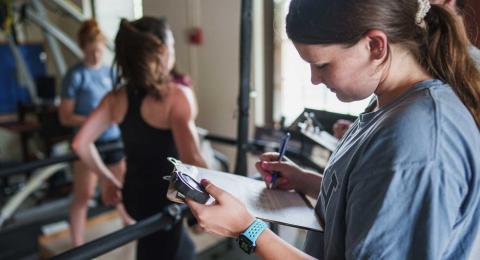 UNH CHHS student measuring health performance of subject on treadmill