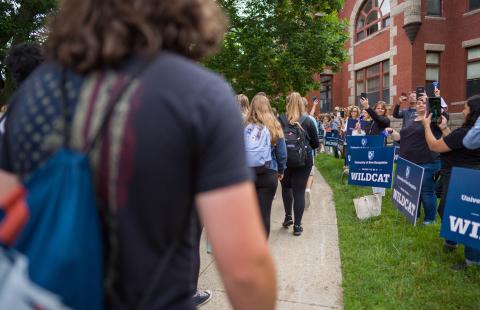 incoming students walk through crowd with Wildcat signs