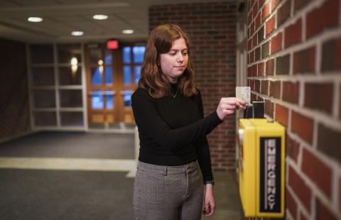 UNH student swiping ID card to enter residence hall building 