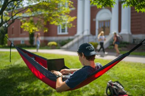 UNH student relaxing in a hammock 
