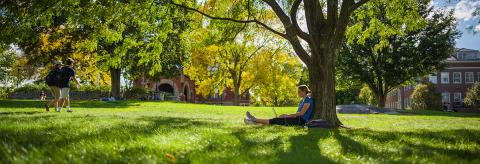 student sitting on T Hall lawn