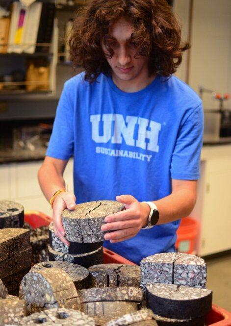 Pedro holding an asphalt testing sample used in Civil Engineering labs