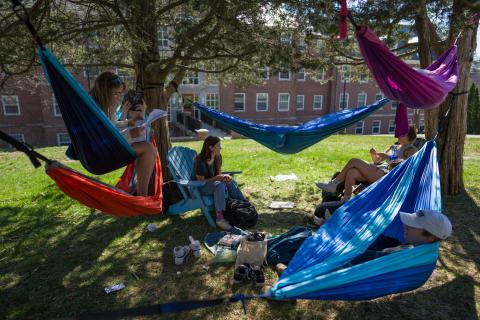 UNH students hanging out in hammocks on campus 