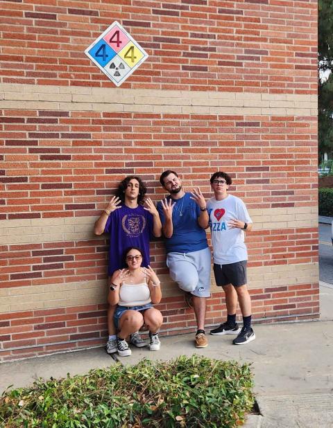 UNH students in front of hazard identification sign