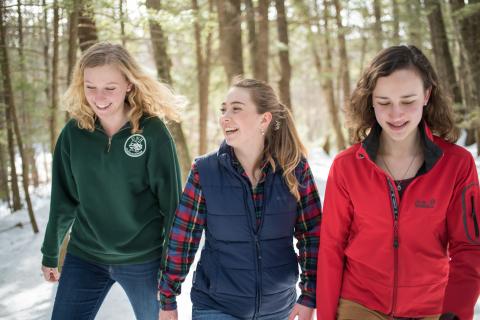 UNH students walking in College Woods in the snow.