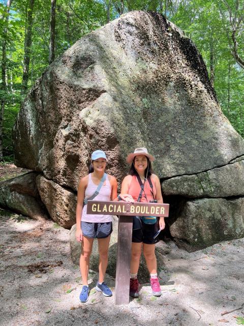 UNH student posing in front of boulder