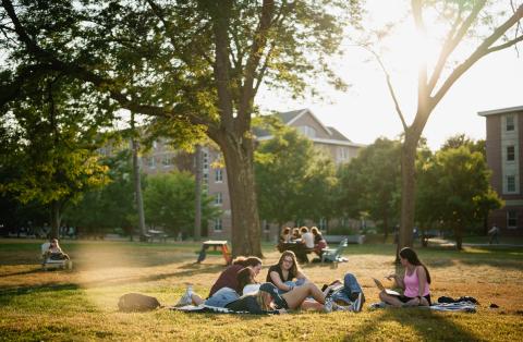 UNH students hanging out on Thompson Hall lawn on campus 