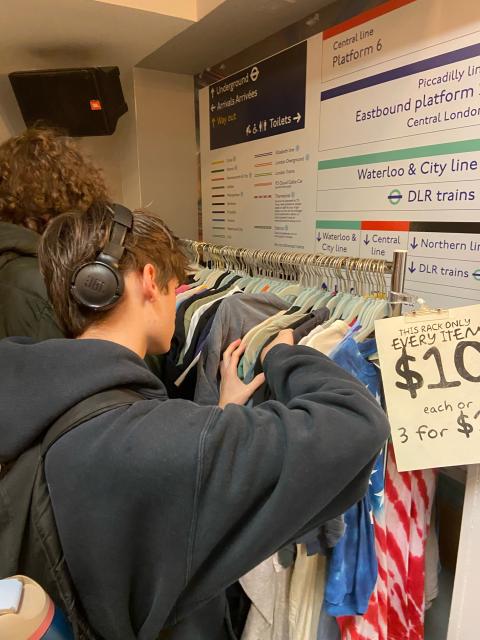 UNH student looking through clothing rack at UNH Fashion Club MUB Underground event