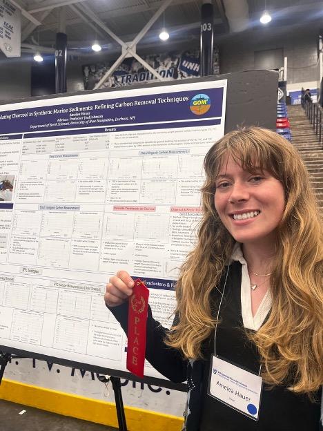 UNH student with research poster