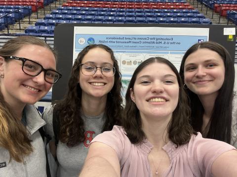 UNH students in front of poster