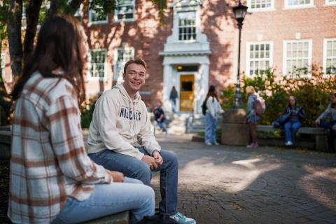 UNH students hanging out outdoors on campus 