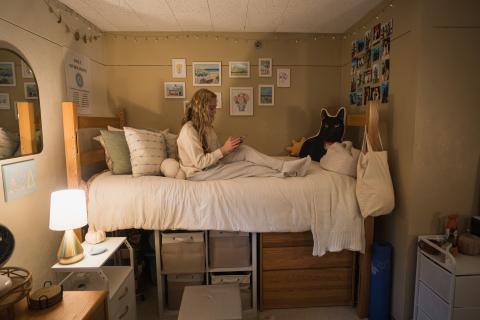 UNH student relaxing in residence hall room 