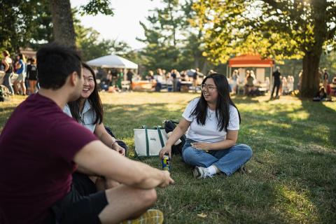 students sitting out on the lawn chatting 