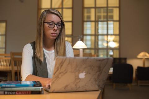 Student reading a book in the UNH Library